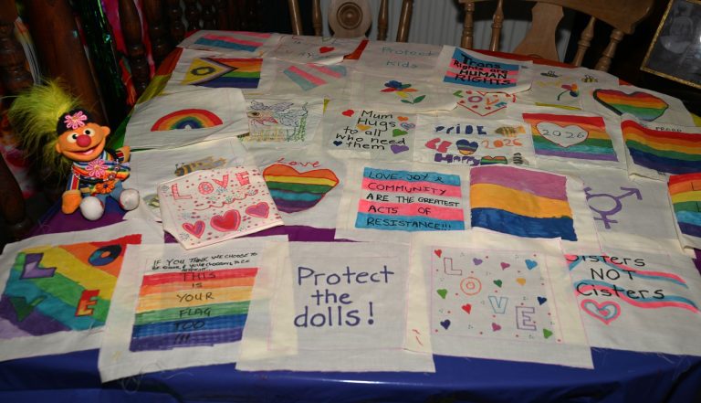 A table of hand-decorated Pride flags and banners from the Cheadle craft session