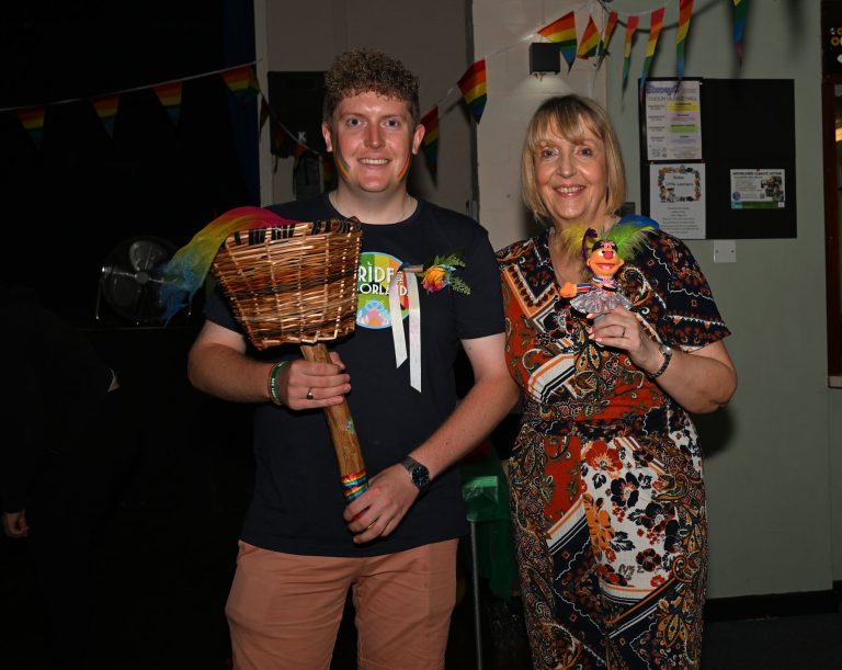 Two people hold the Pride torch at Endon
