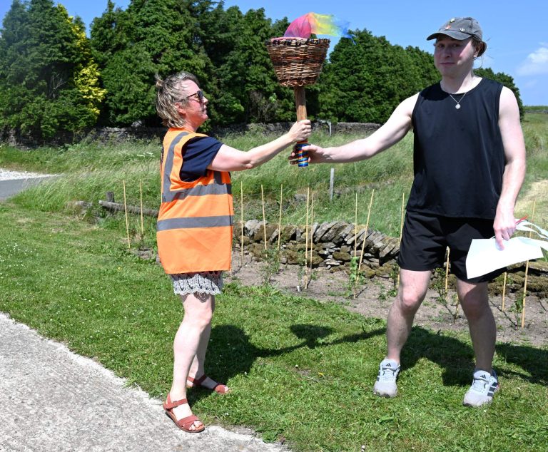 The Pride torch is handed over at the flag raising in Flash