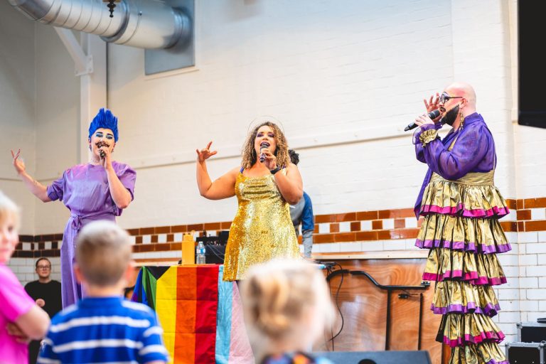 Drag performers sing on stage at Leek Indoor Market