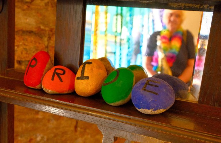 Painted stones spelling out PRIDE on a windowsill