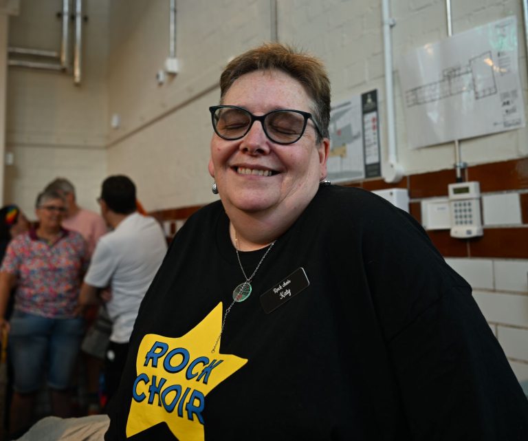 A Rock Choir singer smiles before the performance in Leek