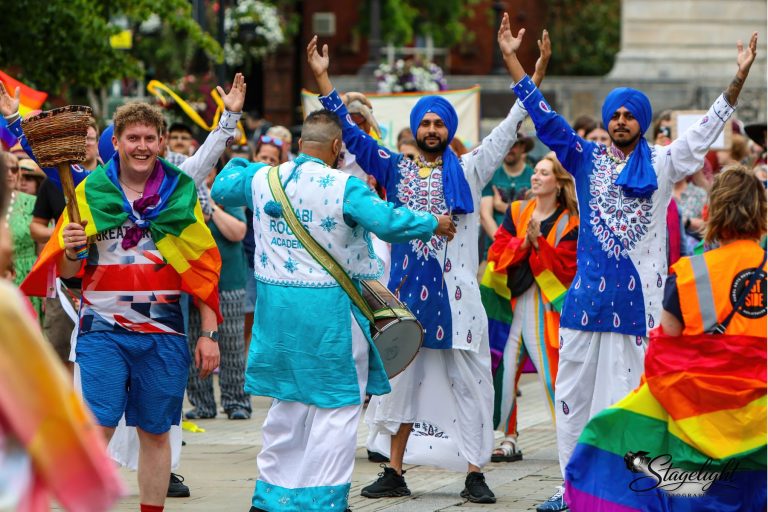 The torch bearer dances with Punjabi Roots bhangra dancers in the Leek parade